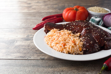 Traditional mole Poblano with rice in plate on wooden table. Copy space	