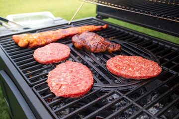 Home barbecue with charcoal in the backyard grilling steaks and other meats for carnivore diet.