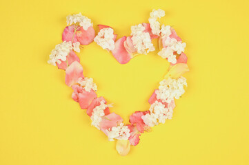  Heart made of petals on a yellow background.