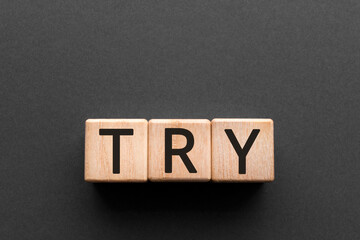 Try - word from wooden blocks with letters, to do something concept, black background