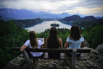 friends sitting on a bench over the Bled lake