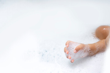 Fototapeta premium baby hands playing with bubble while bathing