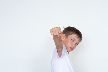 A punching fist. Boy in a white T-shirt with outstretched hand up on a white background. Winner concept. Copy space