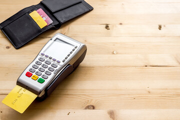 Payment by credit card. Terminal on wooden table copy space