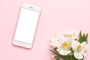 Mobile phone and white flower Alstroemeria on a pink background