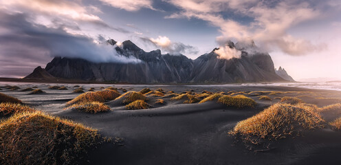 Stunning  dramatic landscape image with cloudy mountain in Iceland during sunset. Impressive Colorful Seascape of Iceland. Wonderful picturesque Scene  near Stokksnes cape and Vestrahorn Mountain - obrazy, fototapety, plakaty