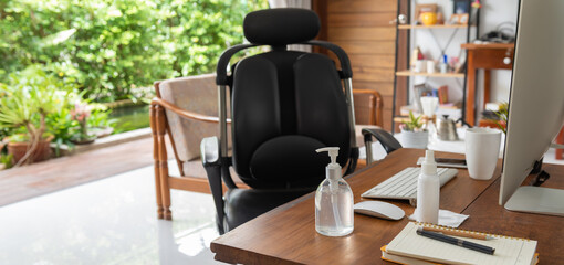 Work from home office gadget hygiene with computer and hand sanitizer protection from coronavirus outbreak or Covid-19