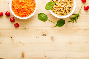 Vegetarian bowl with chickpeas and vegetables - wooden table top view copy space