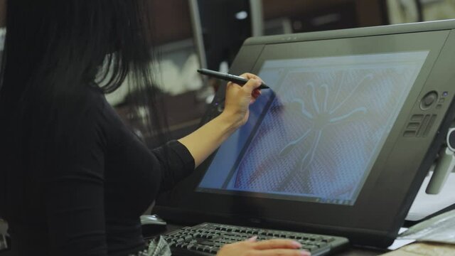 The designer draws on a graphics tablet. Working with interactive pen display. Drawing on a graphics tablet. closeup. Wallpaper production.