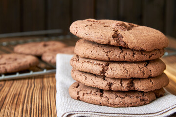 Stacked cookies on brown napkin and on wooden table