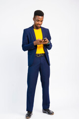 young black handsome man, wearing a suit, smiling while using his smartphone