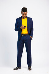 young black handsome man, wearing a suit, smiling while using his smartphone