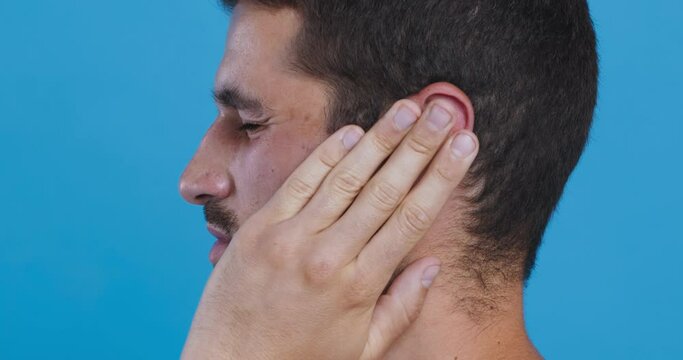 Profile portrait of man touching his head, suffering from ear pain