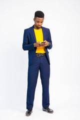 young black handsome man wearing a suit, holding his nose mask and using his smartphone