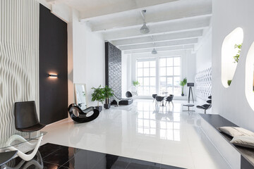 Luxurious futuristic trendy modern interior in contrasting black and white colors with interesting fashionable black furniture and decorated wall