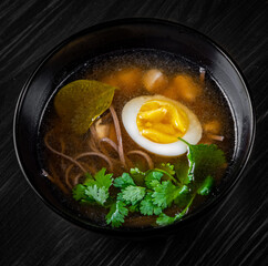soup with tofu and egg on black wooden table background