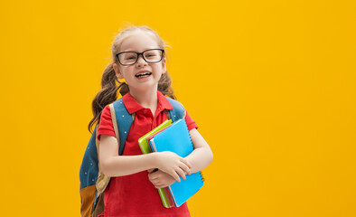 Kid with backpack on color background.