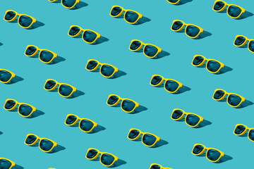 Vivid plastic sunglasses pattern on turquoise blue background. Minimalist background of stylish...