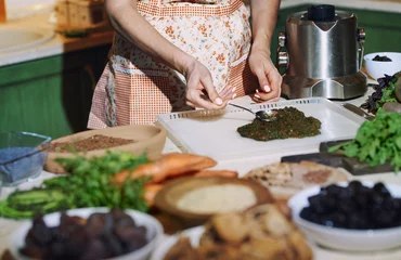Foto op Canvas Staying at home woman preparing and cooking vegetarian food © Arman Zhenikeyev
