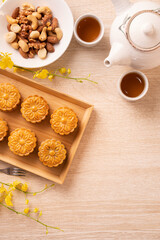 Mid-Autumn Festival holiday concept design of moon cake, mooncakes, tea set on bright wooden table with copy space, top view, flat lay, overhead shot
