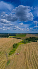 Fototapeta na wymiar A colorful panorama from a 16x9 drone from four frames! Beautiful yellow fields and harvester and blue sky