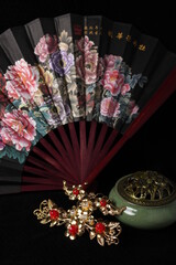 Chinese traditional wedding women's jewelry hairpins. fan and incense burner. still-life