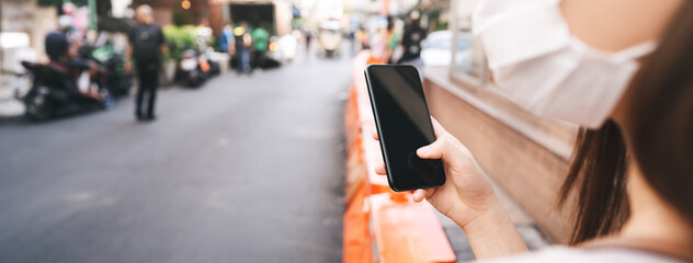 Closed up mobile phone empty screen hold by woman wear face mask
