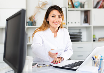 Confident latina woman physician consulting female at clinic, giving prescription