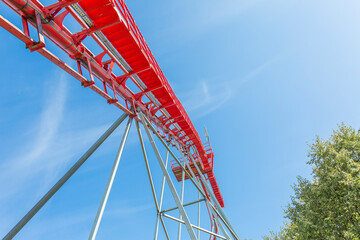 Roller coaster in an amusement park on a blue sky background on a sunny summer day