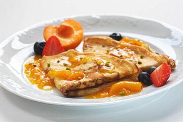 frische Pfannkuchen, Palatschinken mit Aprikosen, Marillen lecker angerichtet auf weißen Teller