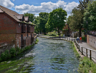Fototapeta na wymiar River Itchen in Winchester flowing between the river walk and medieval buildings.
