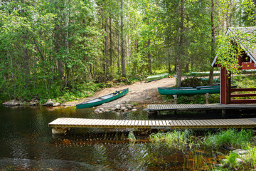 Wooden boat pier and canoe on the shore of the canyon lake Julma-Olkky, Hossa National Park, Kuusamo, Finland