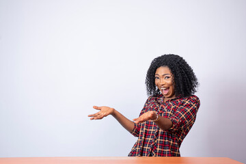 pretty african girl pointing to the space to her side with excitement