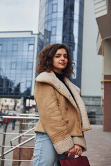 Young girl have a walk outdoors in the city near business building