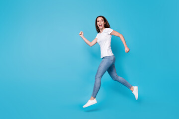 Fototapeta na wymiar Full length body size profile side view of nice active slim fit skinny cheerful cheery girl jumping running marathon motion having fun isolated bright vivid shine vibrant blue color background