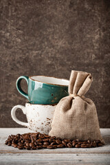Coffee beans and cups on wooden table