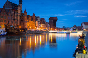 Obraz premium Amazing architecture of Gdansk old town at night with a new footbridge over the Motlawa River. Poland