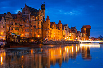 Naklejka na ściany i meble Amazing architecture of Gdansk old town at night with a new footbridge over the Motlawa River. Poland