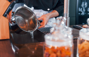 Close up view of professional young chef cook in uniform that working on the kitchen