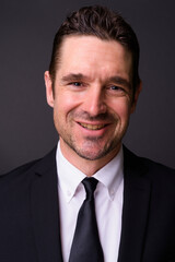 Portrait of happy handsome bearded businessman in suit