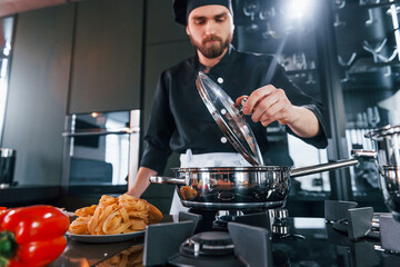 Professional young chef cook in uniform working on the kitchen