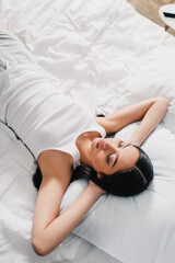 High angle view of young asian woman in sleeveless shirt sleeping on bed at morning