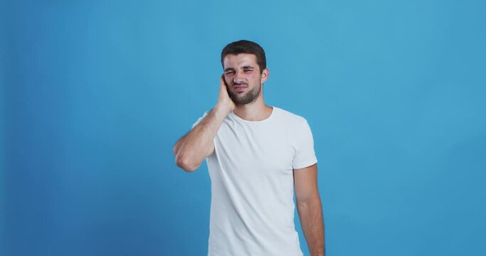 Upset man touching his ear, experiencing pain