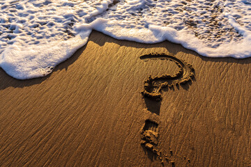 Question Mark Drawn in the Sand at the Ocean