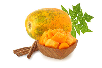 Papaya, pieces in a wooden bowl and cinnamon sticks  with leaf isolated on white