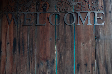 Metal letters "welcome" on the old vintage wooden background
