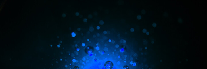 Dark black and blue banner background with bubbles and drops. Magic and mysterious