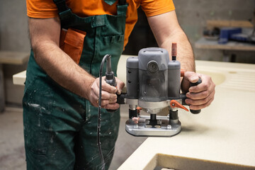 Stone sink furniture production. Carpenter polishes the surface of the sink with a grinder