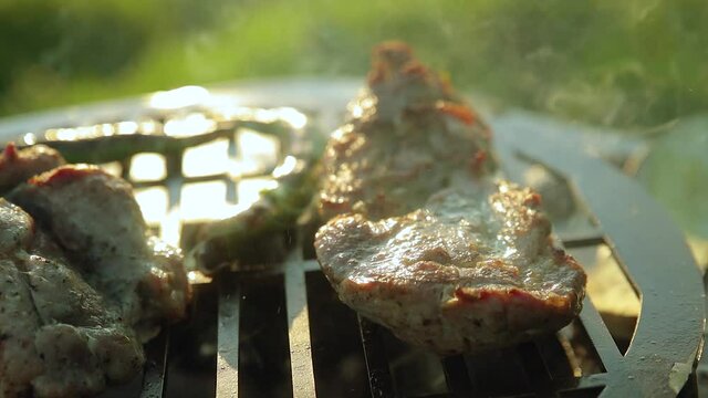 Pieces of steaming grilled pork near chili peppers