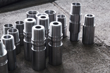 industrial background - new shiny steel hardware, parts of turbodrills of various diameters are in the workshop